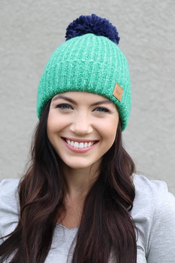 Green fleece lined knit hat with navy pom accent